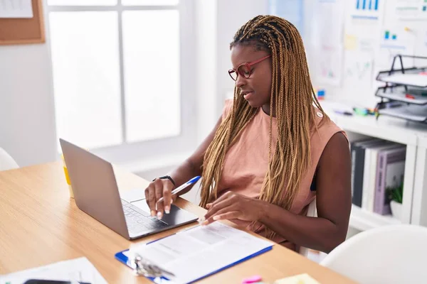 アフリカ系アメリカ人の女性ビジネスワーカーがオフィスでノートパソコンで文書を書く — ストック写真