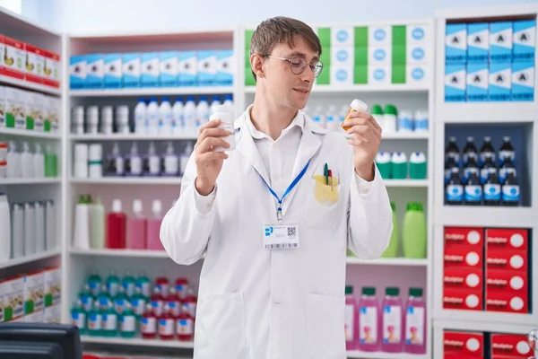 Giovane Uomo Caucasico Farmacista Sorridente Fiducioso Tenendo Bottiglie Pillole Farmacia — Foto Stock