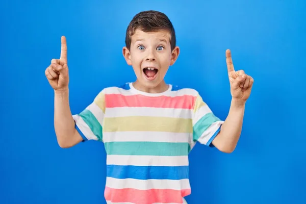 Jovem Caucasiano Criança Sobre Fundo Azul Sorrindo Espantado Surpreso Apontando — Fotografia de Stock