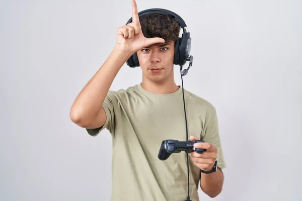 Adolescente Hispânico Jogando Vídeo Game Segurando Controlador Fazendo Piada Pessoas — Fotografia de Stock