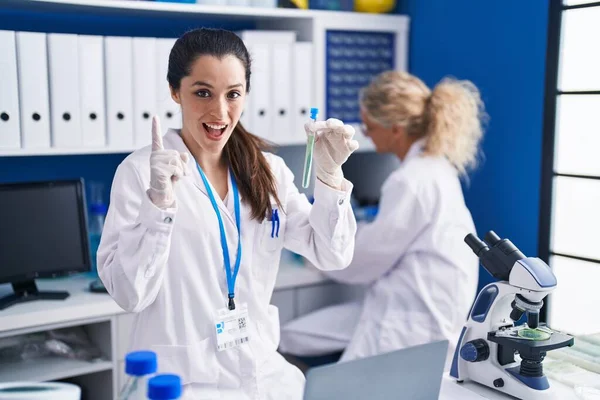 Young Hispanic Woman Working Scientist Laboratory Surprised Idea Question Pointing — Stockfoto