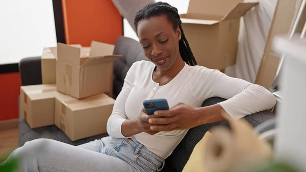 Femme Afro Américaine Utilisant Smartphone Assis Sur Canapé Nouvelle Maison — Photo