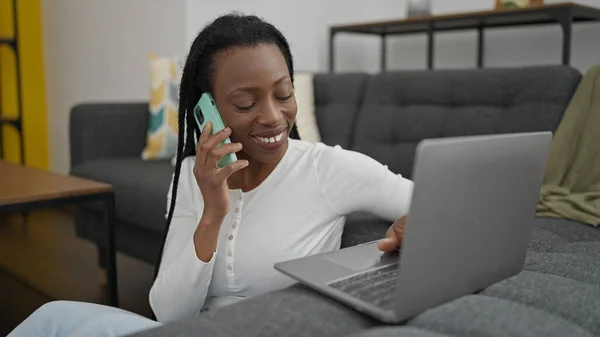 African American Woman Talking Smartphone Using Laptop Home — Stockfoto