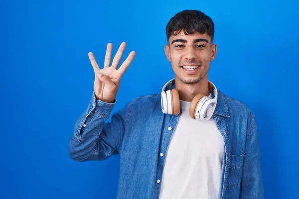 Mavi Arka Planda Duran Spanyol Genç Adam Dört Numarayı Gösterip — Stok fotoğraf