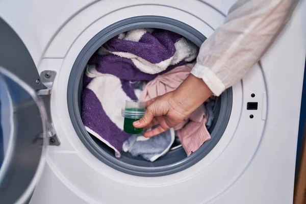 洗衣房的洗衣机上倒洗涤剂的中年妇女 — 图库照片