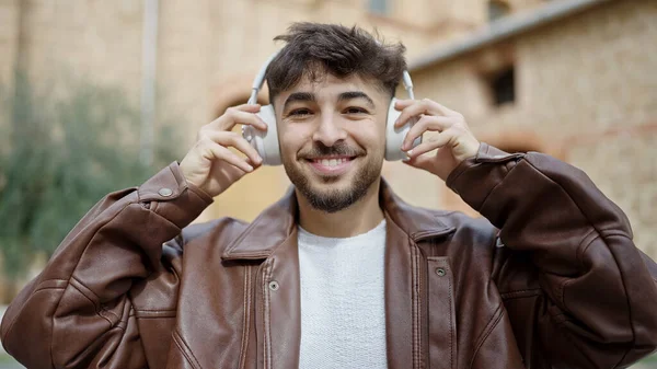 路上で音楽を聞いて自信を持って笑っている若いアラブ人男性 — ストック写真
