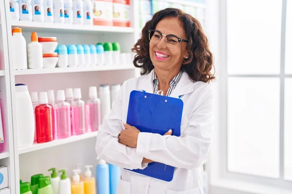 Mujer Mediana Edad Farmacéutico Sonriendo Confiado Sujetando Portapapeles Farmacia — Foto de Stock