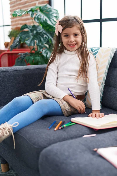 Adorable Hispanic Girl Drawing Notebook Sitting Sofa Home — Stok fotoğraf