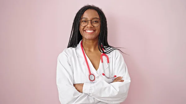 Afrikanische Ärztin Lächelt Selbstbewusst Mit Verschränkten Armen Vor Isoliertem Rosa — Stockfoto