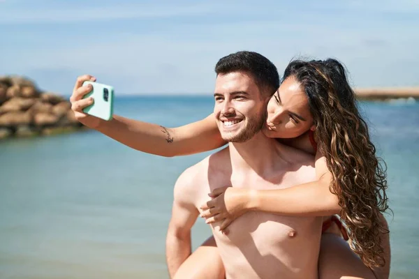 Young Hispanic Couple Tourists Wearing Swimsuit Make Selfie Smartphone Seaside — 스톡 사진