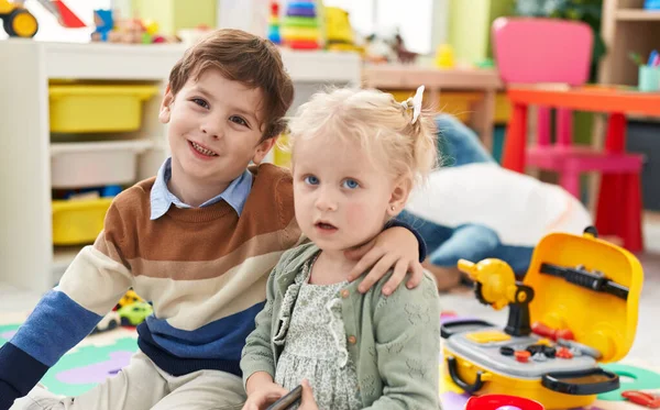 可愛いです男の子と女の子巨大テディベアベッド上のベッドで幼稚園 — ストック写真