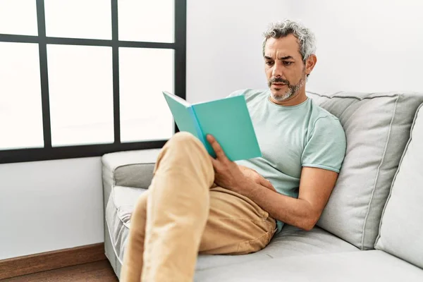 Hombre Pelo Gris Mediana Edad Leyendo Libro Sentado Sofá Casa —  Fotos de Stock