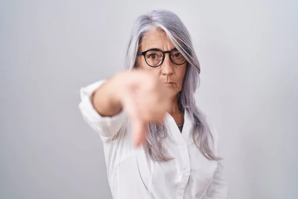 白い背景の上に眼鏡をかけたタトゥーのある中年女性は 親指ダウンジェスチャーで拒絶と否定を示す不満と怒りを見ています 悪い表現 — ストック写真