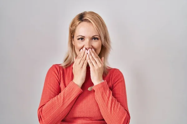 Blonde Woman Standing Isolated Background Laughing Embarrassed Giggle Covering Mouth — Stock Photo, Image