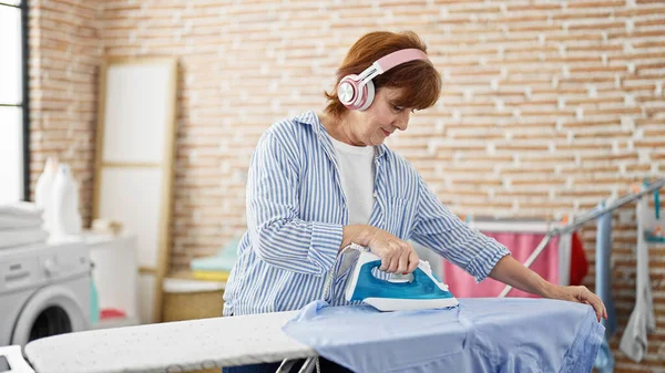 Mujer Mediana Edad Escuchando Música Planchando Ropa Lavandería —  Fotos de Stock