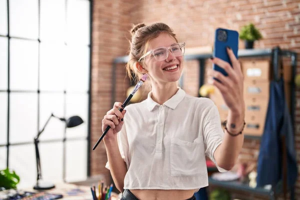 Elinde Fırça Tutan Genç Sarışın Kadın Sanat Stüdyosunda Akıllı Telefondan — Stok fotoğraf