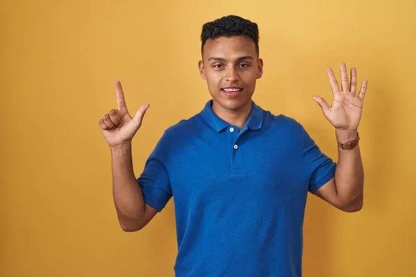 Sarı Arka Planda Duran Spanyol Genç Adam Yedinci Parmaklarını Gösterip — Stok fotoğraf