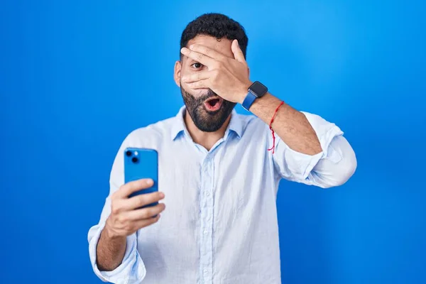 Hombre Hispano Con Barba Usando Mensaje Escritura Teléfonos Inteligentes Asomándose —  Fotos de Stock