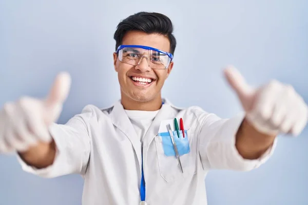 科学者として働くヒスパニック系の男性は 手で積極的なジェスチャーを行うことを承認します 親指アップ笑顔と成功のために幸せ 勝者のジェスチャー — ストック写真