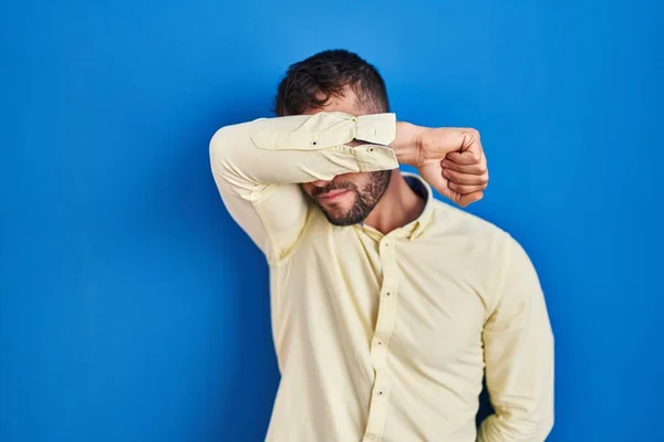 Bonito Hispânico Homem Sobre Fundo Azul Cobrindo Olhos Com Braço — Fotografia de Stock