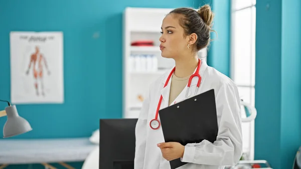 Young Beautiful Hispanic Woman Doctor Standing Serious Expression Holding Clipboard — Stock Photo, Image