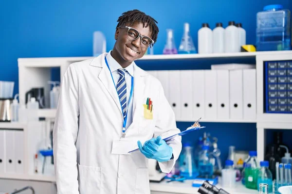 Afrykański Amerykanin Człowiek Naukowiec Uśmiechnięty Pewny Raport Czytania Laboratorium — Zdjęcie stockowe