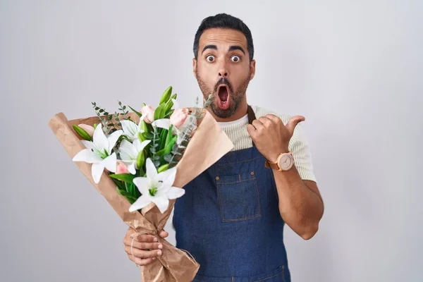 ヒスパニック男として髭を生やして花屋として驚くべきポインティングとともに手指で側面 口を開けて驚くような式 — ストック写真