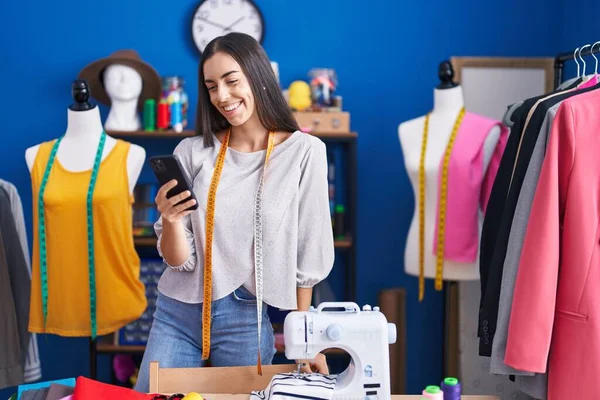 Junge Schöne Hispanische Schneiderin Lächelt Selbstbewusst Mit Smartphone Bekleidungsfabrik — Stockfoto