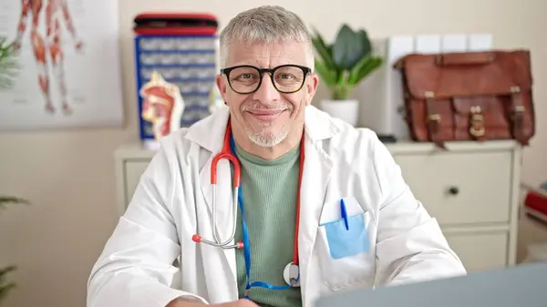 Középkorú Ősz Hajú Férfi Orvos Laptoppal Dolgozik Klinikán — Stock Fotó