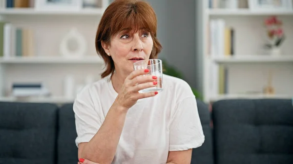 Middelbare Leeftijd Vrouw Drinken Glas Water Zitten Bank Thuis — Stockfoto