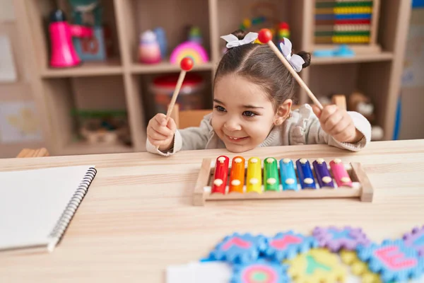 stock image Adorable hispanic girl playing xylophone sitting on table at kindergarten