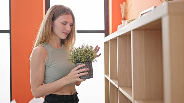 Young Blonde Woman Organizing Shelving Holding Plant Home — Stock Photo, Image