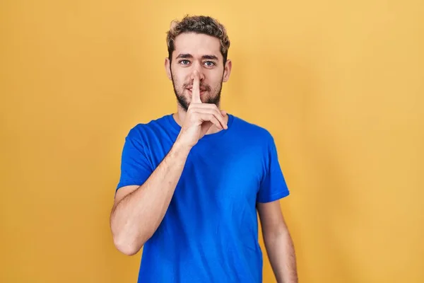 Hispanic Man Beard Standing Yellow Background Asking Quiet Finger Lips — Fotografia de Stock
