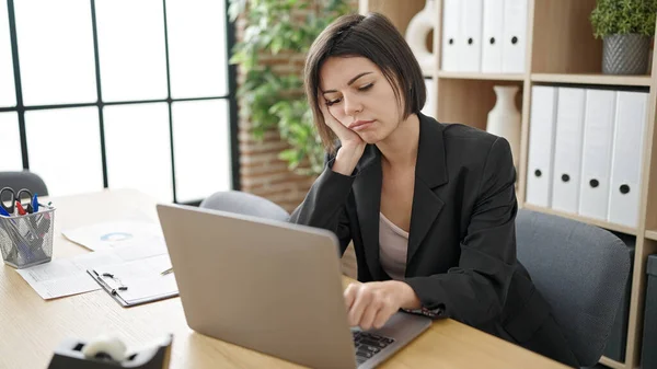 在办公室工作的年轻的高加索女商人厌倦了使用笔记本电脑 — 图库照片