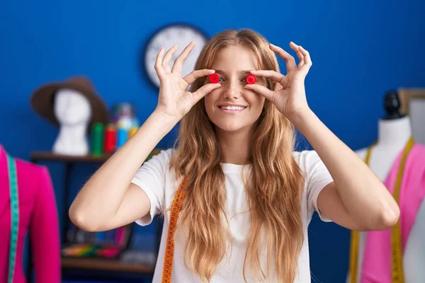 Jovem Loira Alfaiate Sorrindo Confiante Segurando Botões Sobre Olhos Estúdio — Fotografia de Stock