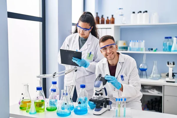 Man Woman Wearing Scientist Uniform Using Microscope Write Document Laboratory — Stock Photo, Image