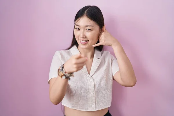 Mujer Joven China Pie Sobre Fondo Rosa Sonriendo Haciendo Hablar —  Fotos de Stock