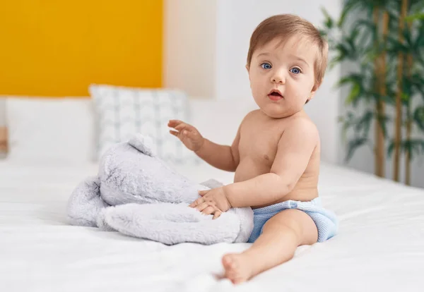 Liebenswertes Kaukasisches Baby Sitzt Auf Bett Und Spielt Mit Puppe — Stockfoto