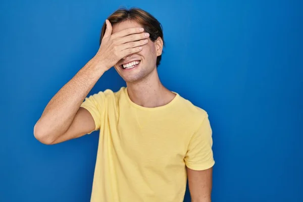 Νεαρός Άνδρας Στέκεται Πάνω Από Μπλε Φόντο Χαμογελώντας Και Γελώντας — Φωτογραφία Αρχείου