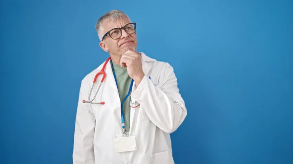 Grauhaariger Arzt Mittleren Alters Steht Mit Zweifelndem Gesichtsausdruck Vor Isoliertem — Stockfoto