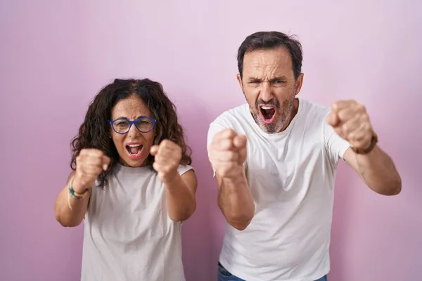 Middelbare Leeftijd Hispanic Paar Samen Roze Achtergrond Boos Gek Opvoeden — Stockfoto