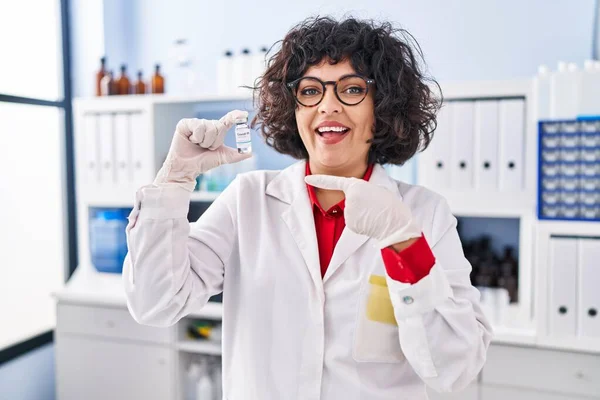 Hispanic Doctor Woman Curly Hair Holding Vaccine Smiling Happy Pointing — Stock Photo, Image