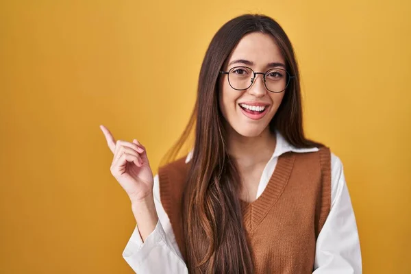 Jovem Morena Sobre Fundo Amarelo Usando Óculos Com Grande Sorriso — Fotografia de Stock