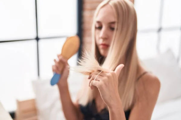 Junge Blonde Frau Kämmt Haare Mit Ernstem Gesichtsausdruck Schlafzimmer — Stockfoto
