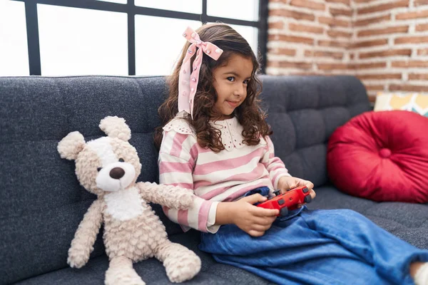 可爱的惊慌姑娘坐在家里的沙发上玩电子游戏 — 图库照片