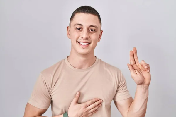Young Man Standing Isolated Background Smiling Swearing Hand Chest Fingers — Stock Photo, Image