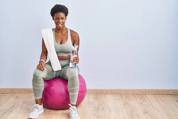 Afrikansk Amerikansk Kvinna Sportkläder Sitter Pilates Boll Blinkar Tittar Kameran — Stockfoto