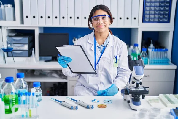 Hispánská Mladá Žena Pracující Laboratoři Vědců Usmívá Dívá Stranou Přemýšlí — Stock fotografie