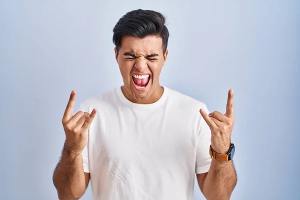 Hispanic Man Standing Blue Background Shouting Crazy Expression Doing Rock — Stockfoto