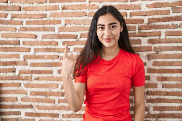 Tuğla Duvarın Üzerinde Duran Genç Kız Bir Numaralı Parmağını Gösterip — Stok fotoğraf